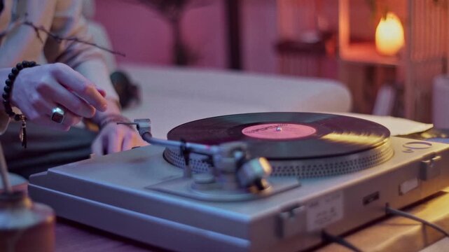 Man carefully listening to vintage vinyl while blowing dust off record