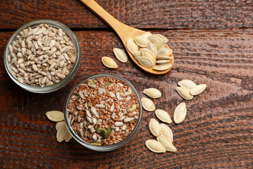 Different seeds on wooden table, flat lay