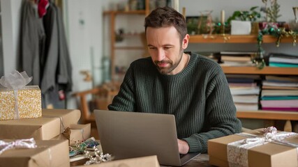 Cheerful small business owner working on a laptop, managing online orders, and preparing gifts for shipping in a cozy, festive workshop during the bustling christmas holiday season - Powered by Adobe