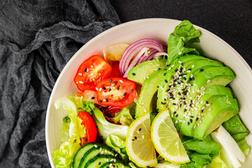 Avocado salad egg, tomato, onion, green leaf salad vegetable dish natural tasty snack fresh gourmet food background on the table rustic top view copy space keto and paleo diet vegan and vegan food