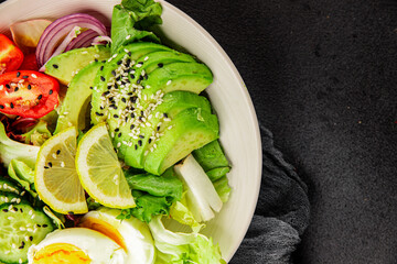 Avocado salad egg, tomato, onion, green leaf salad vegetable dish natural tasty snack fresh gourmet food background on the table rustic top view copy space keto and paleo diet vegan and vegan food