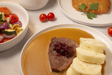Traditional Czech dish close-up. Svickova na smetane served with dumplings and sauce. Classic national meal representing Czech gastronomy and home cooking culture. Svichkova closeup.