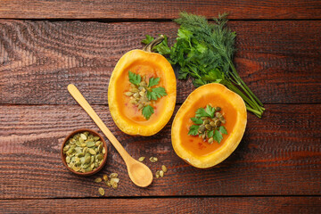 Tasty pumpkin cream soup with seeds, parsley and dill on wooden table, flat lay