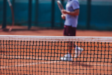 Tennis tournament championship on outdoor clay court with net, professional athletes play in motion with rackets serve tennis ball during tennis match game, tennis training in a sunny day on a stadium