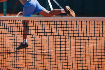 Tennis tournament championship on outdoor clay court with net, professional athletes play in motion with rackets serve tennis ball during tennis match game, tennis training in a sunny day on a stadium