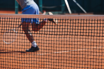 Tennis tournament championship on outdoor clay court with net, professional athletes play in motion with rackets serve tennis ball during tennis match game, tennis training in a sunny day on a stadium