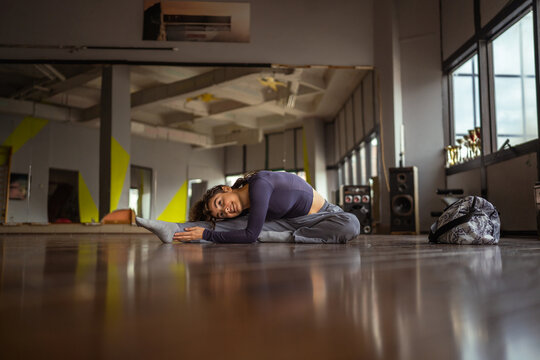 Young dancer stretching leg in dance studio - Powered by Adobe