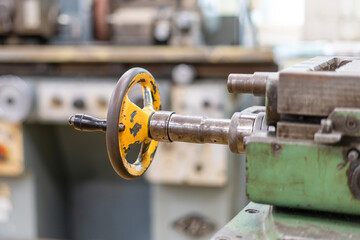 Old worn out milling machine control panel and control dial in a workshop