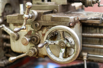 Old worn out milling machine control panel and control dial in a workshop