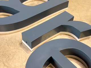 3D Metal Letters Fabrication Process with Matte Finish on Workshop Table