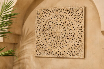 Ornate carved wall panel with geometric mandala pattern in warm beige Mediterranean interior