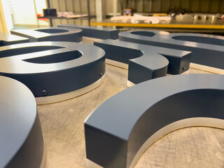 3D Metal Letters Fabrication Process with Matte Finish on Workshop Table