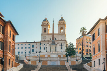 Trinita dei Monti church and empty Spanish Steps with historic buildings at sunrise in old town of Rome city, Italy. Italian architecture. Popular travel and touristic destination in Europe