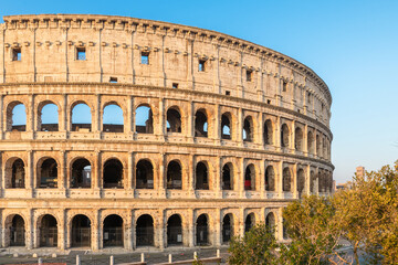 Side view of ancient Roman Colosseum Amphitheater in Rome city, Italy at sunrise. Italian architecture. Popular touristic and travel landmark