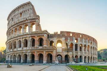Ancient Colosseum Amphitheater in Rome city, Italy illuminated by soft morning light at sunrise with nobody. Italian architecture. Popular touristic and travel landmark