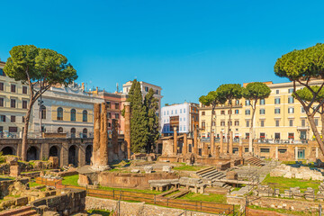 Roman square Largo di Torre Argentina in Rome, Italy. Ancient ruins of four Roman Republican temples and Pompey's Theatre surrounded by colorful buildings. Italian architecture. Archaeological site