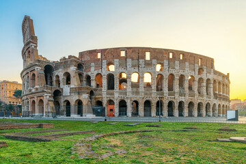 Ancient Colosseum Amphitheater in Rome city, Italy illuminated by soft morning light at sunrise with nobody. Italian architecture. Popular touristic and travel landmark