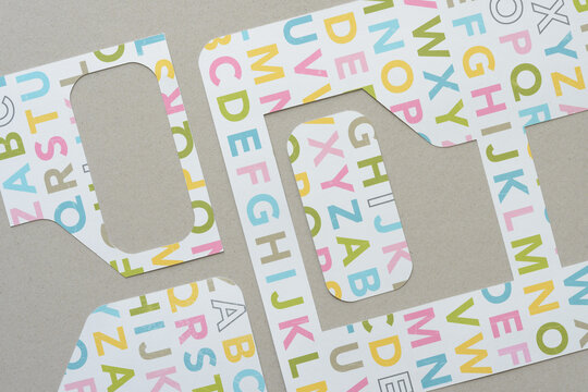 abstract cut paper shapes with letters on mill board - Powered by Adobe