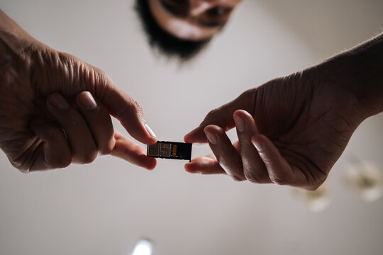 Low-angle view of man replacing sim card in mobile phone, providing efficient and reliable technical support to customer. Concept of smartphone maintenance and service.