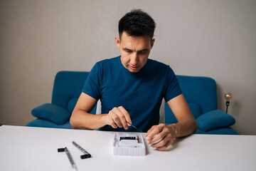 Portrait of technician male assembling wi-fi module using specialized tools at home office desk, focusing on intricate components and ensuring proper connection. Concept of desktop PC maintenance