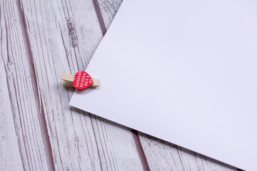 a heart-shaped clothespin on a piece of paper