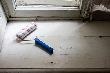 a paint roller is on an old windowsill