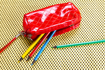 colored pencils in a red bag on a yellow napkin