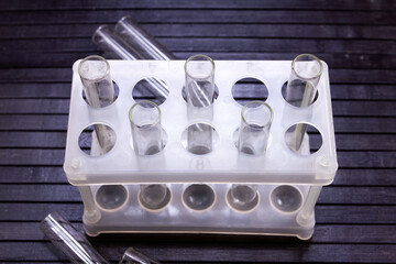 glass test tubes in a rack and on a black background