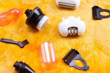 shaving and epilator attachments on an orange background