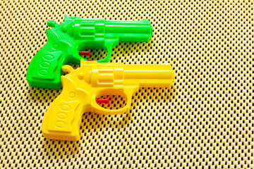 two water pistols, green and yellow