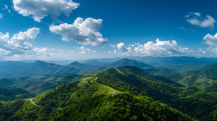 Fototapeta premium Stunning Aerial View of Lush Green Mountain Range under Blue Sky with Clouds