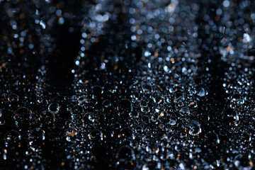 Fototapeta premium raindrops on a dark background.water drops on glass in close-up. Abstract dark background. Mockup for your logo. horizontal wallpaper or web banner.