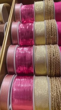 Gift wrapping materials: ribbons. Decorative items prepared for packaging presents and festive occasions. Vertical video of ribbon close-up. 