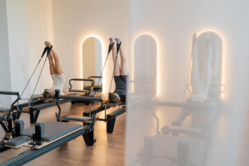 Peaceful reformer studio with natural light, Calm Pilates space featuring warm lighting and wooden