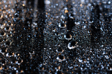 raindrops on a dark background.water drops on glass in close-up. Abstract dark background. Mockup for your logo. horizontal wallpaper or web banner.