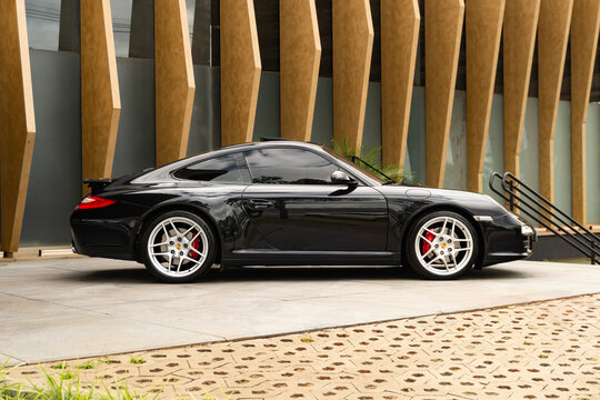 Black Porsche 911 Carrera 4S side profile, timeless luxury sportscar