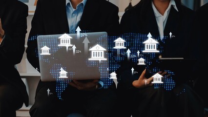 Two business professionals analyze global financial data while using technology, with digital graphics illustrating banks and a map, symbolizing modern finance. Raster