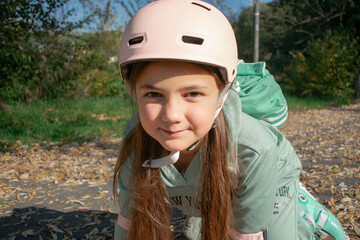 A cheerful 8-year-old girl roller skates through an autumn park filled with colorful leaves....