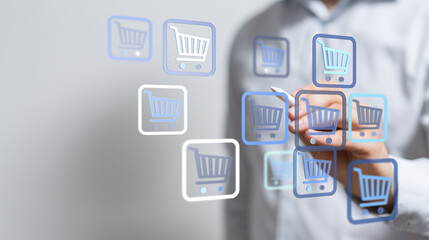 Fototapeta premium A person uses a stylus to interact with shopping cart icons, representing online shopping, ecommerce, and digital retail concepts.