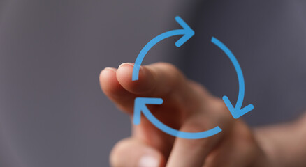 Hand pointing at an arrow circle, representing cycles, renewal, and process. Perfect for business, environment and technology concepts.