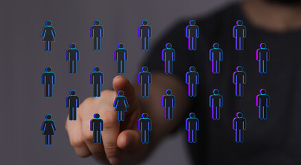 Concept of selection or choice represented by a hand pointing at people symbols. Digital...