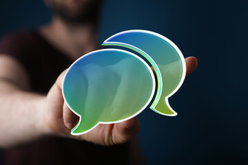 Close-up of a hand with digital speech bubbles. Concept of communication, dialog, conversation, information. Modern technology, social media.