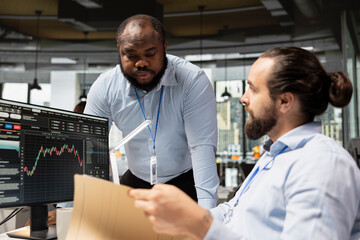 Prop firm manager supervising employee in office, analyzing market data together for better results. Forex business team leader and worker discuss stock exchange investing opportunities