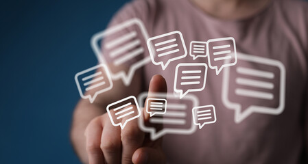 Close-up of a person's finger touching message bubbles symbolizing communication and social...