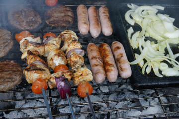 meat cooking in the garden on a barbecue, tasty summer food outdoors 
