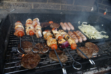 meat cooking in the garden on a barbecue, tasty summer food outdoors 