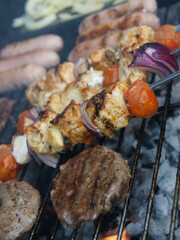 meat cooking in the garden on a barbecue, tasty summer food outdoors 