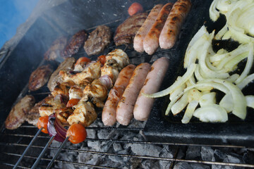 meat cooking in the garden on a barbecue, tasty summer food outdoors 