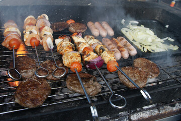 meat cooking in the garden on a barbecue, tasty summer food outdoors 
