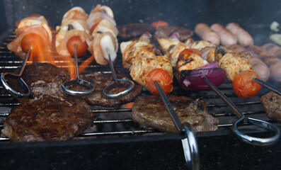 meat cooking in the garden on a barbecue, tasty summer food outdoors 